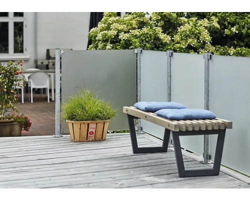 Uteplats med vindskydd, träbänk med kuddar och krukväxt