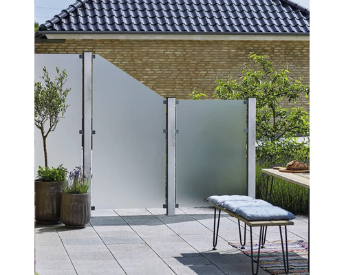 Terrass med insynsskydd av glas, planteringar och sittbänk