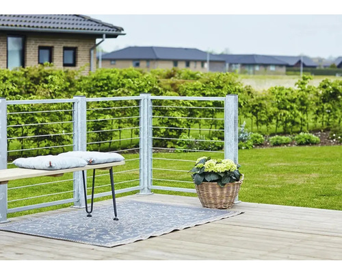 Uteplats med bänk, utomhusmatta, blomkorg och räcke