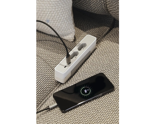 Grenuttag och en smarttelefon anslutna med en laddningskabel.