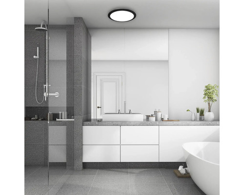 Ljust badrum med dusch, tvättställ, spegel, badkar och taklampa