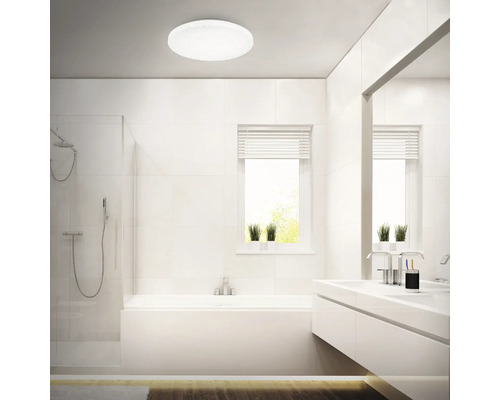 Ljust badrum med dusch, badkar, tvättställ och rund taklampa