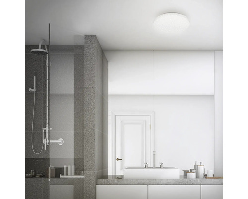 Ljust badrum med dusch, handfat och taklampa