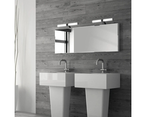 Badrum med två handfat, spegel och vägglampor