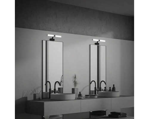 Badrum med två handfat, speglar och belysning