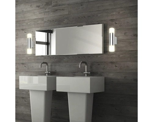 Badrum med dubbla handfat, spegel och vägglampor