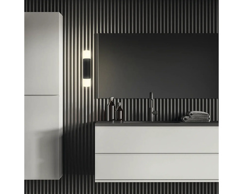 Modernt badrum med tvättställ, spegel, vägglampa och badrumsskåp för en stilfull atmosfär