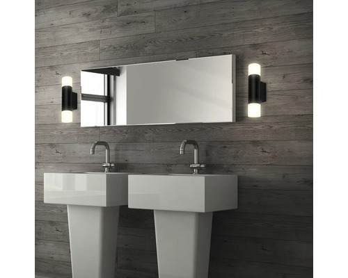 Badrum med två handfat, spegel och vägglampor