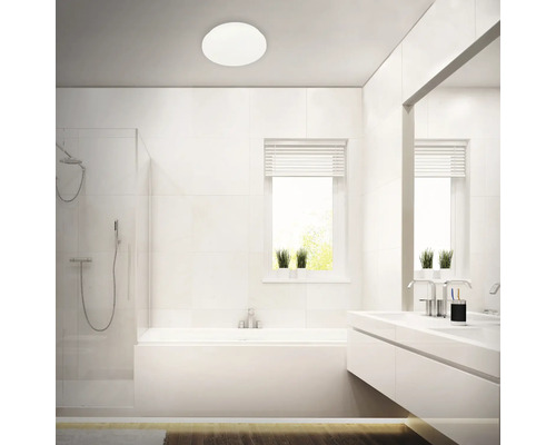 Modernt badrum med dusch, badkar, handfat och rund taklampa