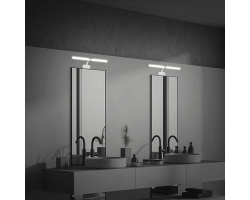 Modernt badrum med två handfat, speglar och belysta spegelskåp.