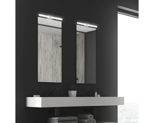 Modernt badrum med två speglar, handfat och handdukar