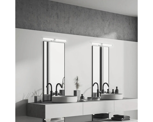 Ljust badrum med två handfat, speglar och belysning