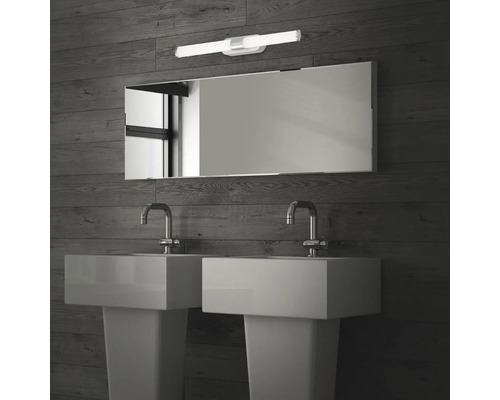 Badrum med två handfat, spegel och vägglampa