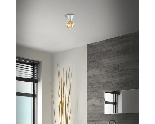 Modernt badrum med taklampa, spegel och träpaneler