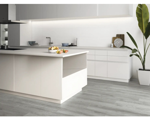 Ljust kök med köksö, diskho och krukväxt