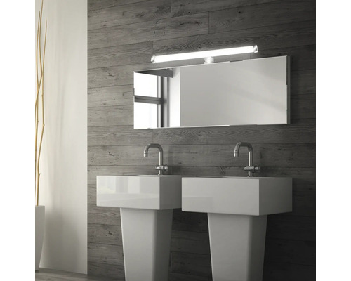 Badrum med två handfat, spegel och vägglampa