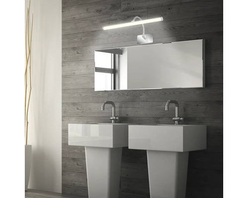 Badrum med två handfat, spegel och spegellampa