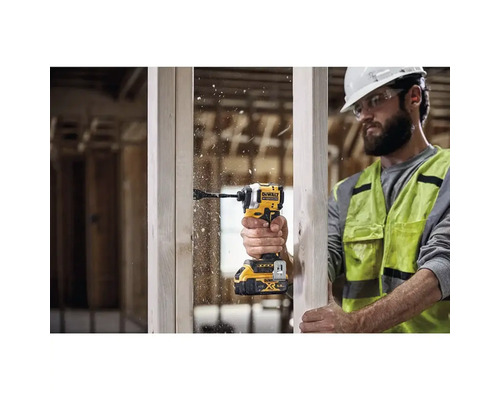 En man borrar ett hål i en träbit med en DeWalt sladdlös slagskruvdragare.