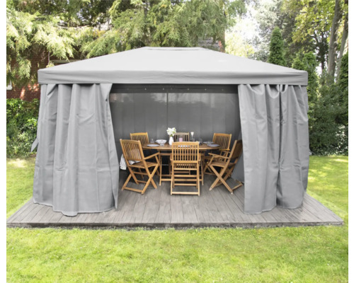 Paviljong med gardiner och trädgårdsmöbler på en terrass i trädgården