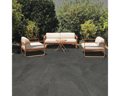 Uteplats med sittgrupp och mörka golvplattor utomhus.