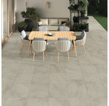 Terrass med golvplattor, trädgårdsbord och stolar.