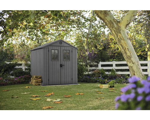 Trädgård med redskapsbod, trästaket och träd