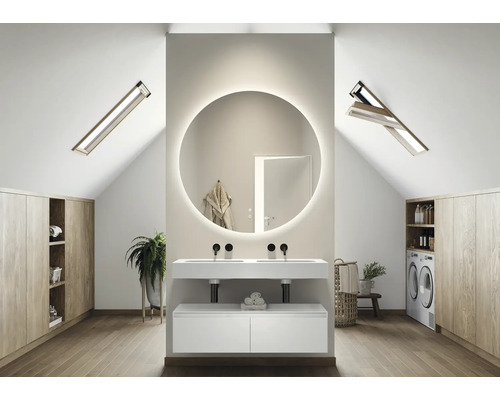 Ljust badrum på vinden med rund spegel, tvättställsskåp, takfönster och inbyggda skåp.