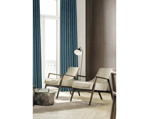 Vardagsrum med gardiner, två fåtöljer och en golvlampa