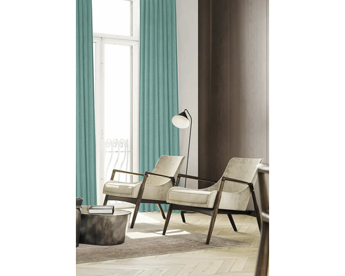 Vardagsrum med gardiner, fåtöljer och golvlampa