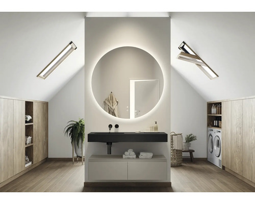 Modernt badrum på vinden med rund spegel, tvättställ och takfönster.