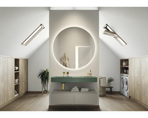 Modernt badrum på vinden med rund spegel, handfat och tvättmaskin