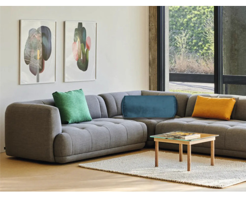 Vardagsrum med grå hörnsoffa, kuddar och soffbord