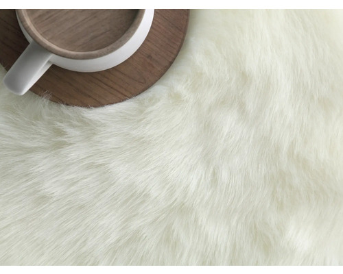 Detaljvy av en matta med långa fibrer bredvid en kopp på ett träfat.