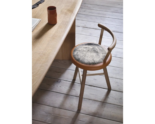 Trästol med fuskpälskudde vid bord