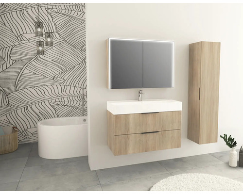 Badrum med tvättställsskåp, spegelskåp, högskåp och badkar.