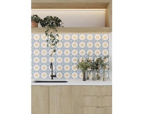 Ljust kök med diskho, kran och väggplattor med blommönster