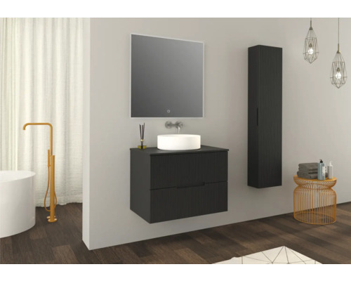 Badrum med tvättställsskåp, spegel, högskåp, badkar och tillbehör.