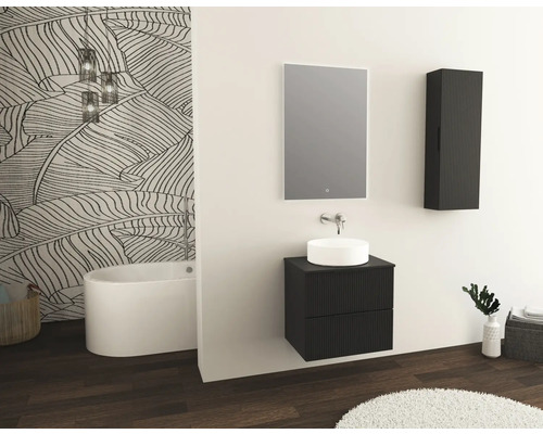 Badrum med fristående badkar, tvättställsskåp, spegel och väggskåp