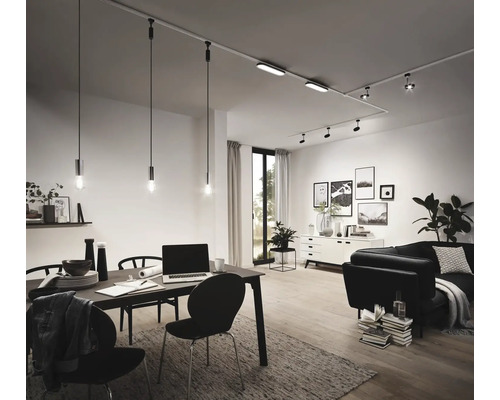 Vardagsrum med matbord, soffa och belysning via ett skensystem med spotlights och pendellampor