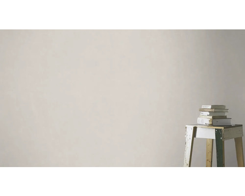 Ljus vägg med stapel böcker på en pall