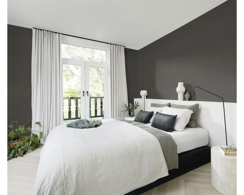 Ljust sovrum med dubbelsäng, gardiner och krukväxter