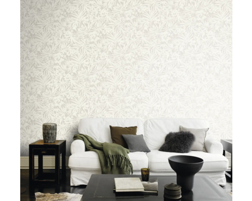 Ljust vardagsrum med mönstrad tapet, vit soffa och mörkt soffbord