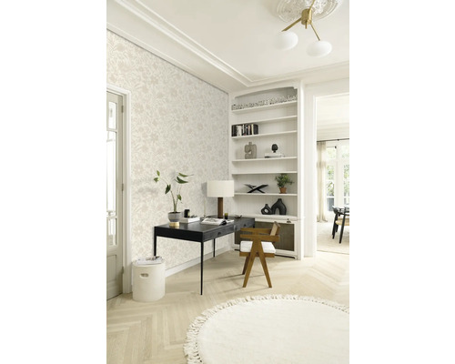 En ljus arbetsplats med blommönstrad tapet, ett svart skrivbord och en rund matta