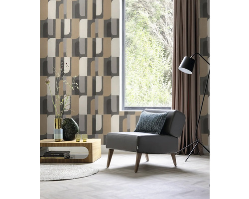 Vardagsrum med fåtölj, lampa, fönster och mönstrad tapet