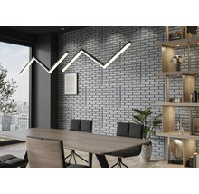 Mötesrum med matbord, stolar och hylla mot en stenvägg med en modern sicksacklampa