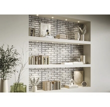 Dekorativ väggbeklädnad med stenpaneler i ett vardagsrums hylla med böcker och vaser