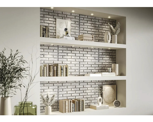 Dekorativ väggbeklädnad med stenpaneler i ett vardagsrums hylla med böcker och vaser