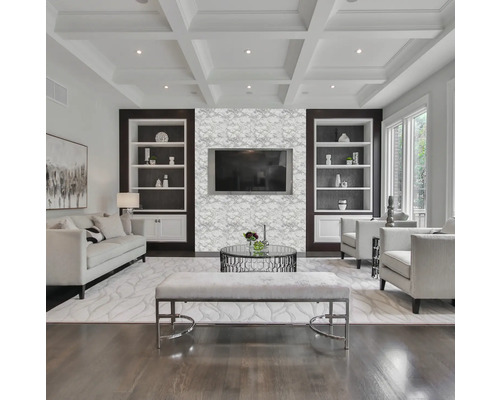 Ljust vardagsrum med soffa, fåtöljer, soffbord, bänk och inbyggda hyllor