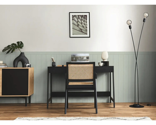 Inredning med skrivbord, stol, golvlampa och byrå i ett arbetsrum.