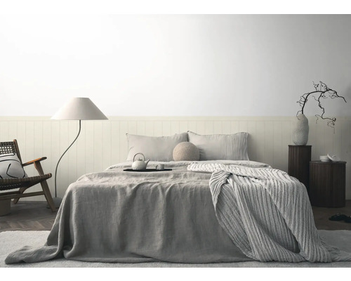 Sovrum med säng, sängbord, golvlampa och stol